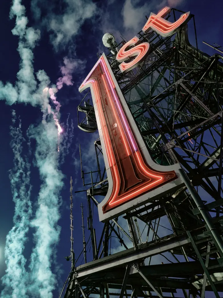 Fireworks rising past the relit “1st” sign on the First National Bank Building